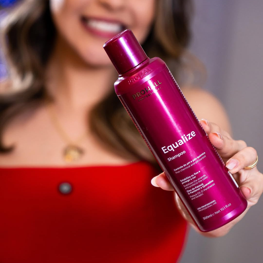 Woman holding a pink bottle labeled 'Equalize' against a neutral background