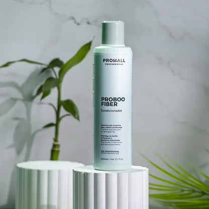 Prohall Proboo Fiber bottle on a white cylindrical stand with a plant in the background