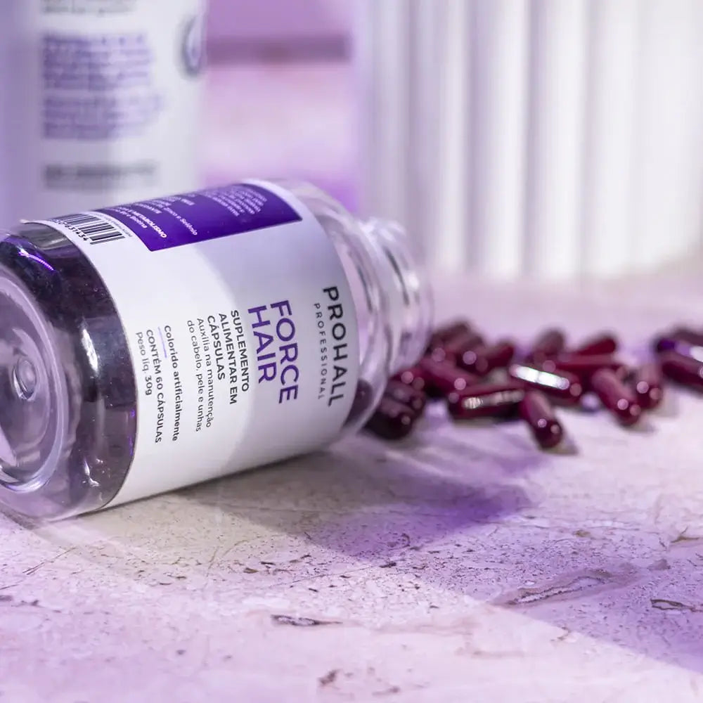 Bottle of ProHair Force Professional Hair Supplement with scattered capsules on a marble surface.