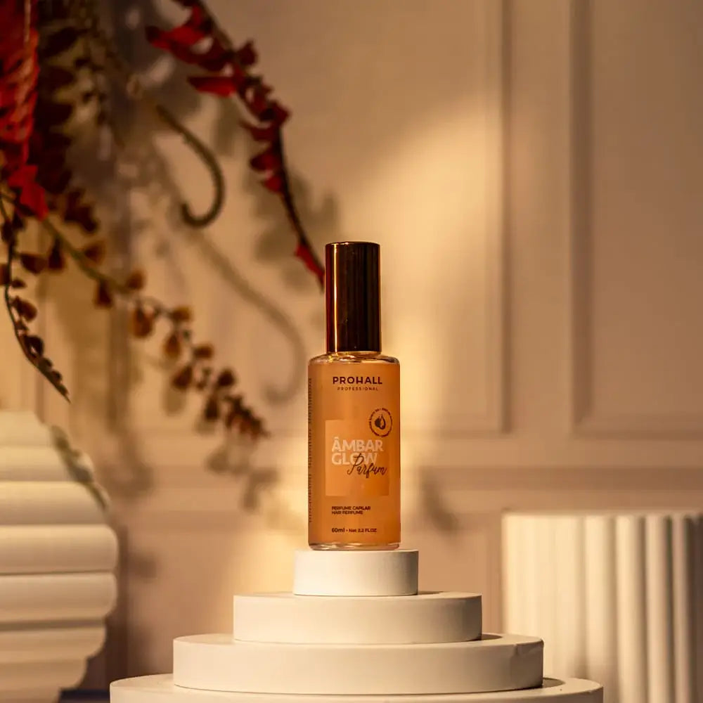 Amber glow serum bottle on a white pedestal with decorative elements in the background