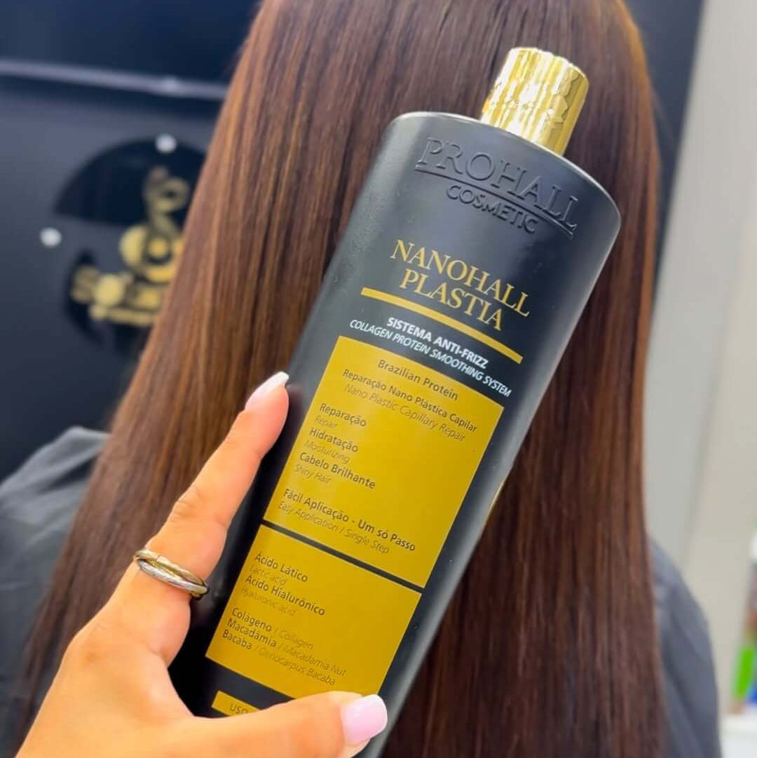 Person holding a bottle of 'Nanohall Plastia' hair product with a blurred background