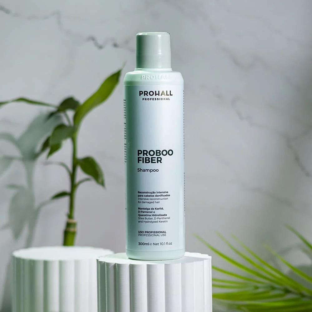 Probooo Fiber shampoo bottle on a reflective surface with a plant in the background