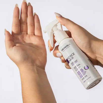 Hand holding a spray bottle labeled 'Prohall Force Hair' with another hand showing hair product on palm.
